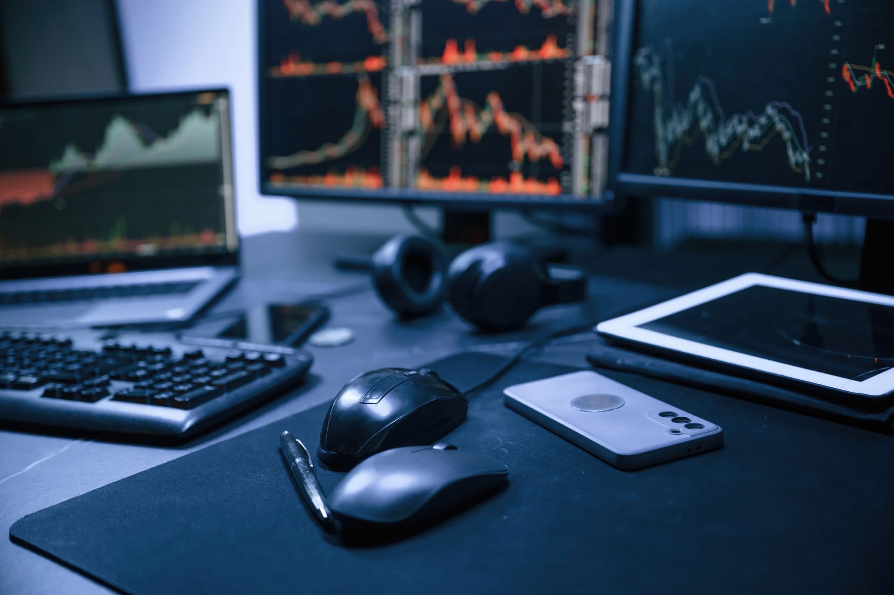 Multi-screen trading workstation with live market charts and devices, illustrating professional setups used by mt5 mt4 brokers in Singapore